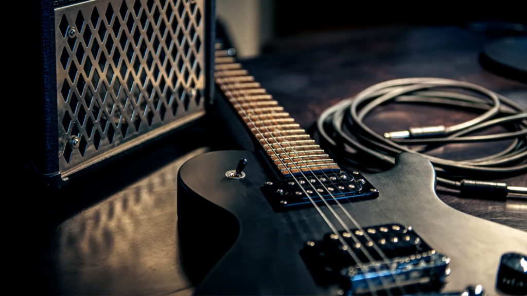 Guitarra deitada ao lado da caixa de som, para explicar se ela é igual ao violão