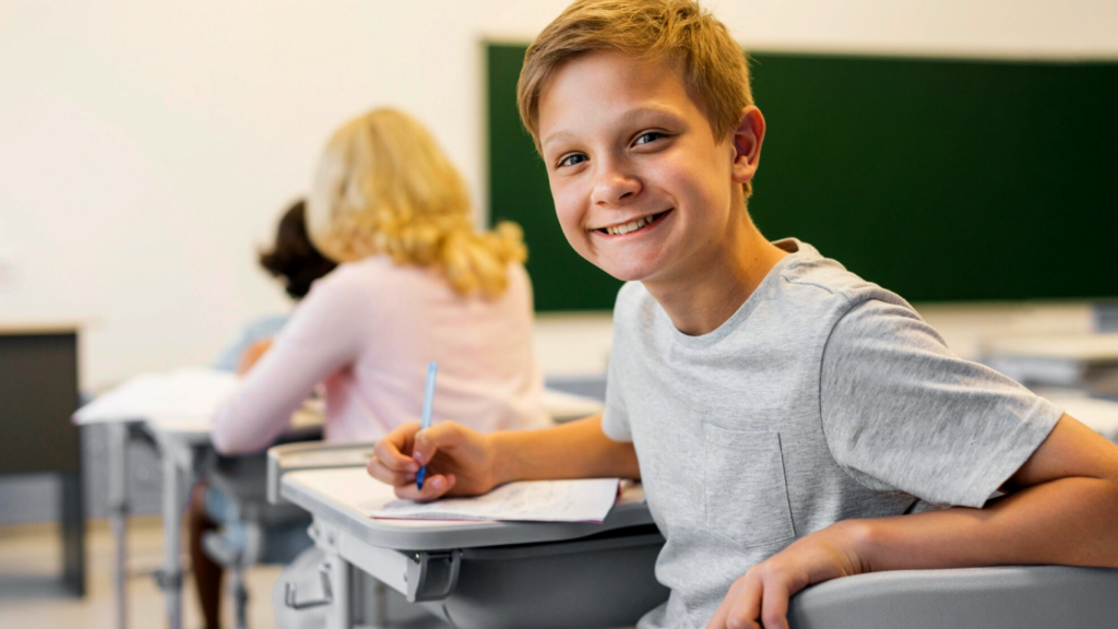 Aluno sorrindo na sala de aula, pois aprender dá prazer